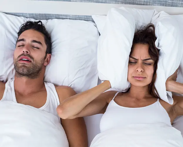 Woman being annoyed by snoring man