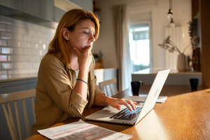 Concerned-looking woman sitting at laptop